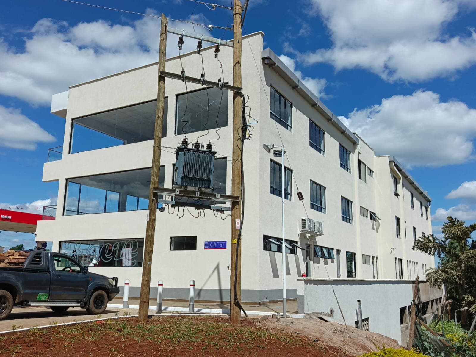 Site development — three-storey petroleum retail shell with fuel canopy edge, transformer infrastructure, and coordinated civil works on the forecourt.